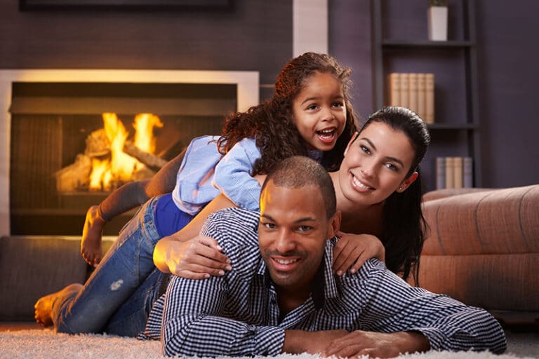 blog-fireplace-family - Sweep Your Chimney family enjoying themselves in front of a fireplace